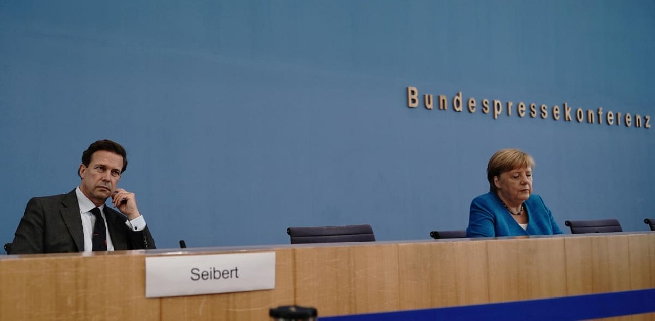 German government's spokesperson Steffen Seibert with Chancellor Angela Merkel. Credit: Reuters Photo