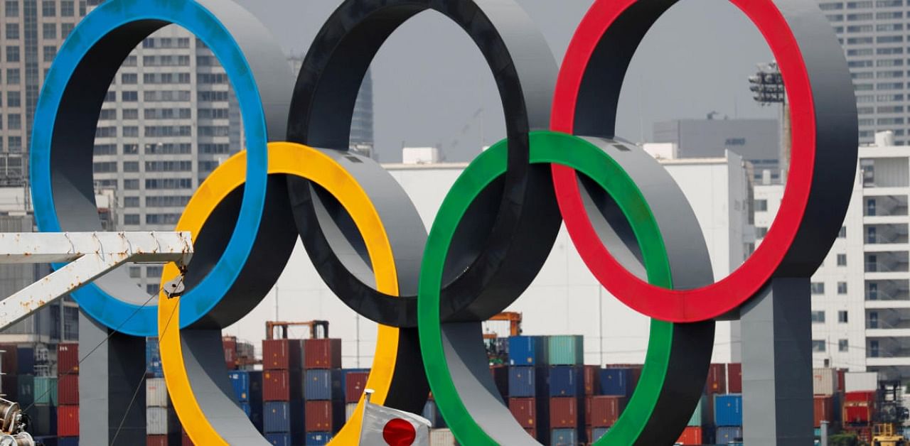 The giant Olympic rings, which are being temporarily removed for maintenance, are seen behind Japan's national flag. Credit: Reuters