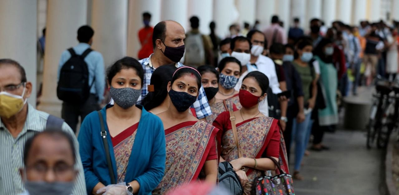 People wearing protective face masks stand in a line to enter a metro station amidst the spread of the coronavirus disease in New Delhi. Credit: Reuters