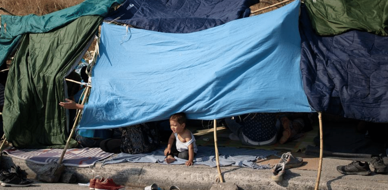 A baby sits in a tent as refugees and migrants from the destroyed Moria camp are sheltered near a new temporary camp, on the island of Lesbos. Credit: Reuters