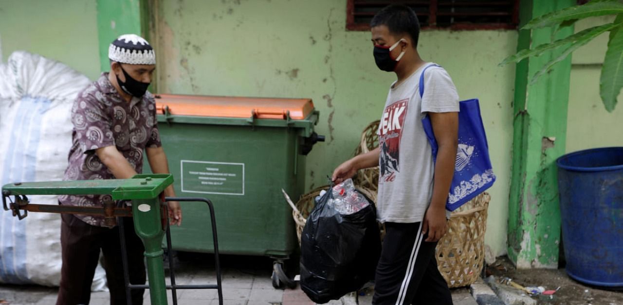 A student wearing a protective mask carries a bag of plastic bottles to be exchanged for internet wifi access for online studying, amid the coronavirus disease. Credit: Reuters