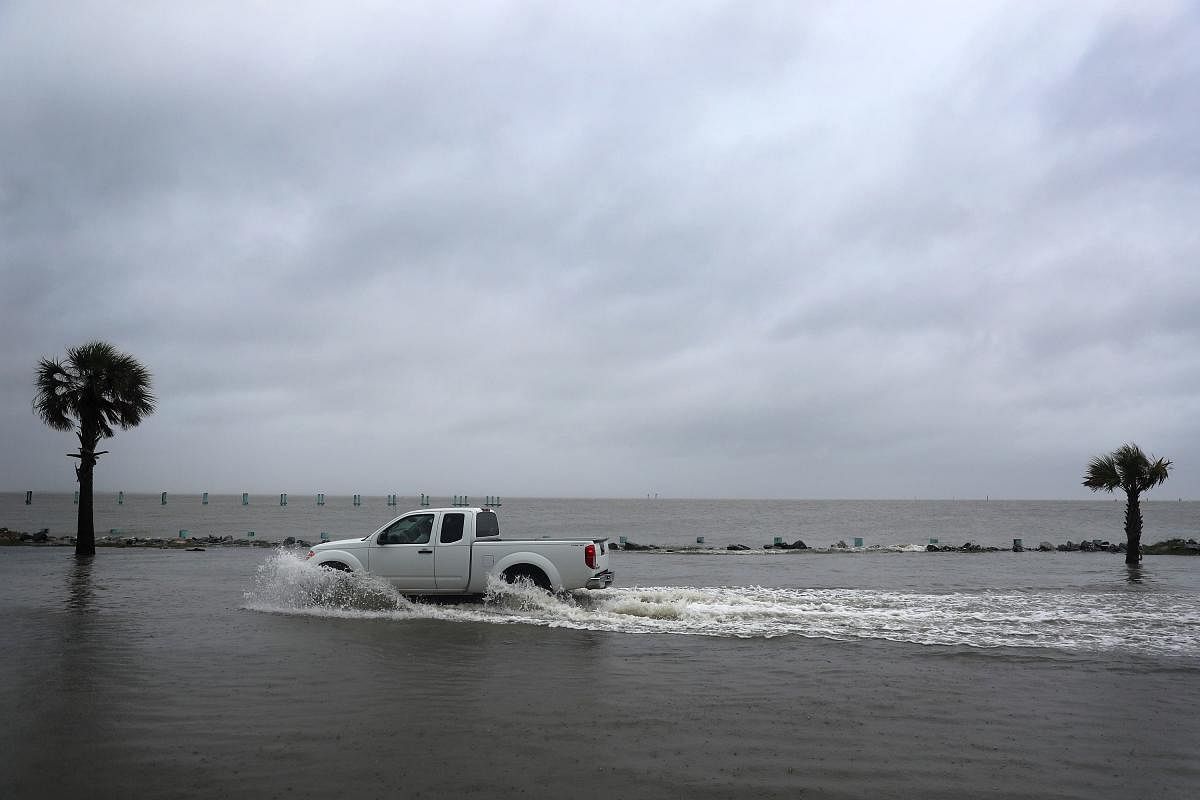 A driver navigates along a flooded road as the outer bands of Hurricane Sally come ashore. Credit: AFP