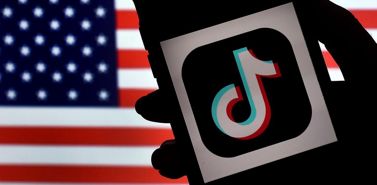 TikTok is displayed on the screen of an iPhone on an American flag background. Credit: AFP