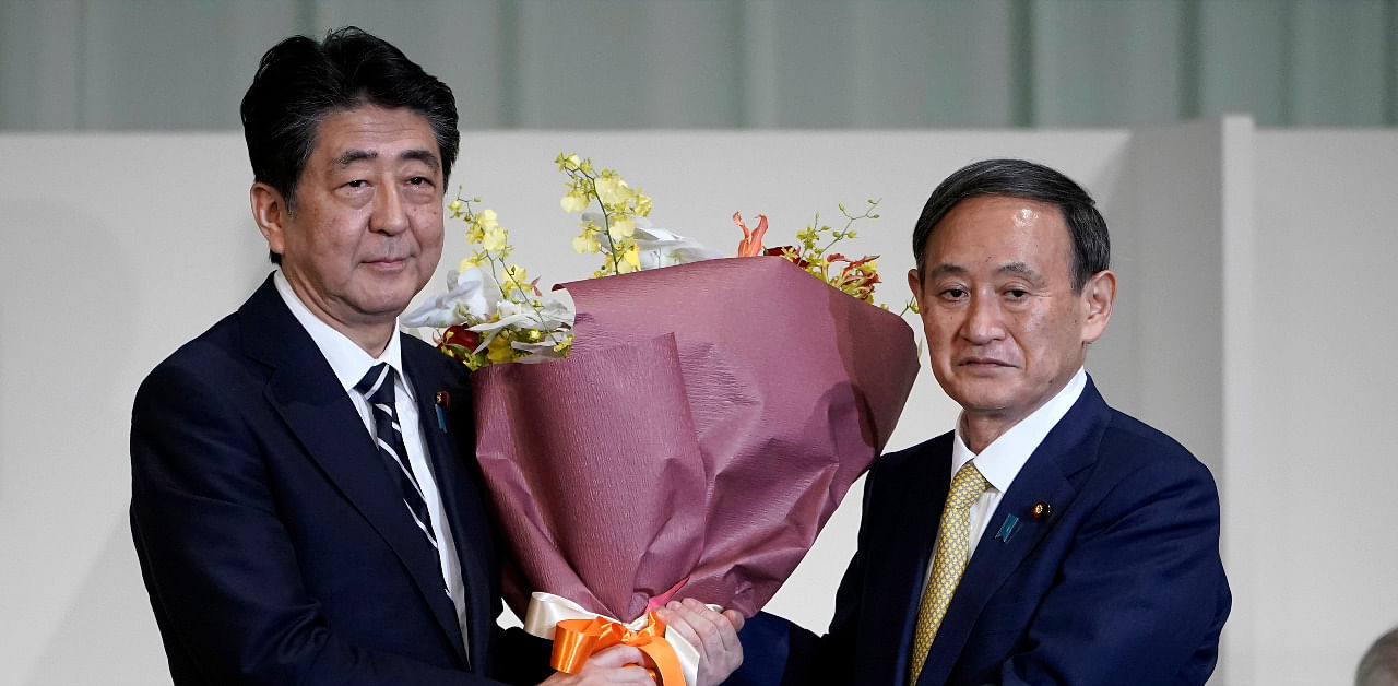 Japan PM Abe with successor Yoshihide Suga. Credit: AP Photo