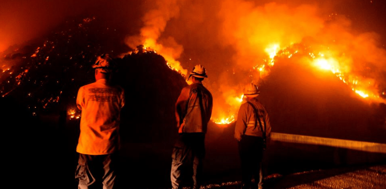 Firefighters watch the Bobcat Fire burning on hillsides near Monrovia Canyon Park in Monrovia, California. Credit: AFP