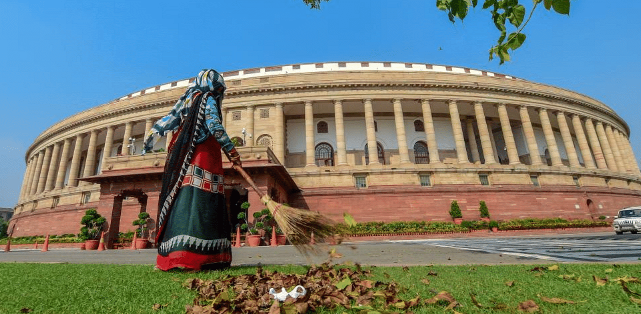 A civic worker sweeps a lawn in the premises of Parliament House during the ongoing Monsoon Session, in New Delhi, Tuesday, Sept. 15, 2020. Credit: PTI Photo