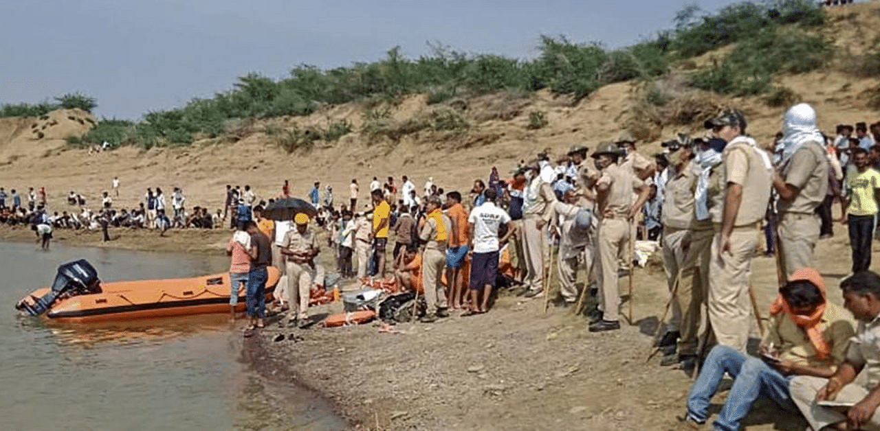National Disaster Response Force (NDRF) personnel carry out search operations for missing people after a boat sank while crossing Chambal River in the Etawah region of Kota district. Credit: PTI
