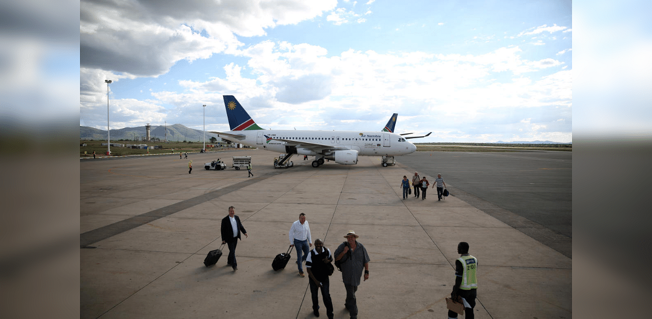 Passengers walk past an AirNamibia aircraft at the Hosea Kutako International Airport, outside Windhoek in Namibia . Credit: Reuters
