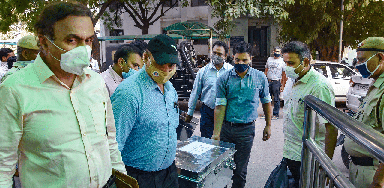Deputy Commissioner of Police (Special Cell) Pramod Singh (L) Kushwaha with his team brings chargesheet papers related to North-East Delhi riots in February, at Karkardooma Court in New Delhi. Credit: PTI Photo