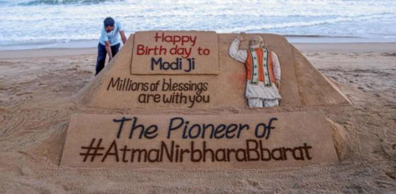 Sand artist Sudarsan Pattnaik gives finishing touch to a sand sculpture dedicated to PM Narendra Modi, ahead of his birthday, in Puri. Credit: PTI Photo