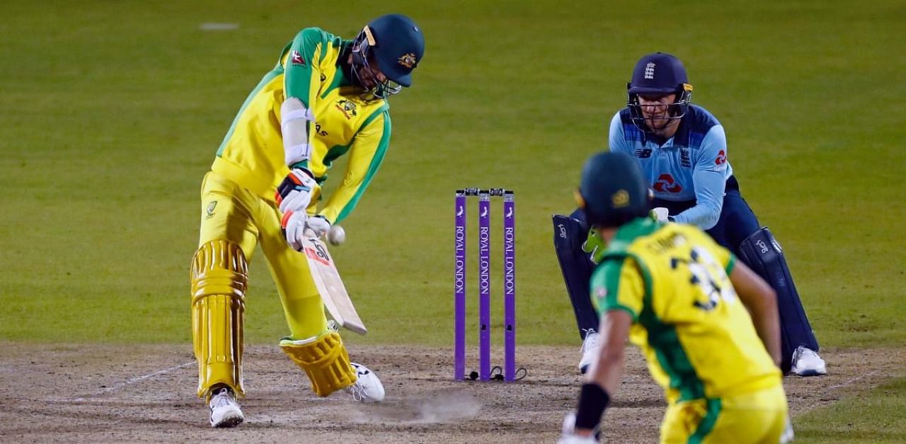 Australia's Mitchell Starc (L) hits the ball for six runs in the final over during the one-day international (ODI) cricket match between England and Australia at Old Trafford in Manchester. Credit: AFP