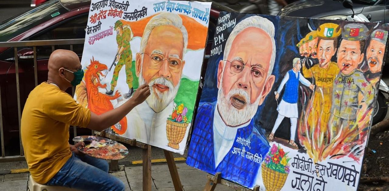 An artist makes a painting on the eve of Prime Minister Narendra Modi's 70th Birthday, in Mumbai. Credit: PTI