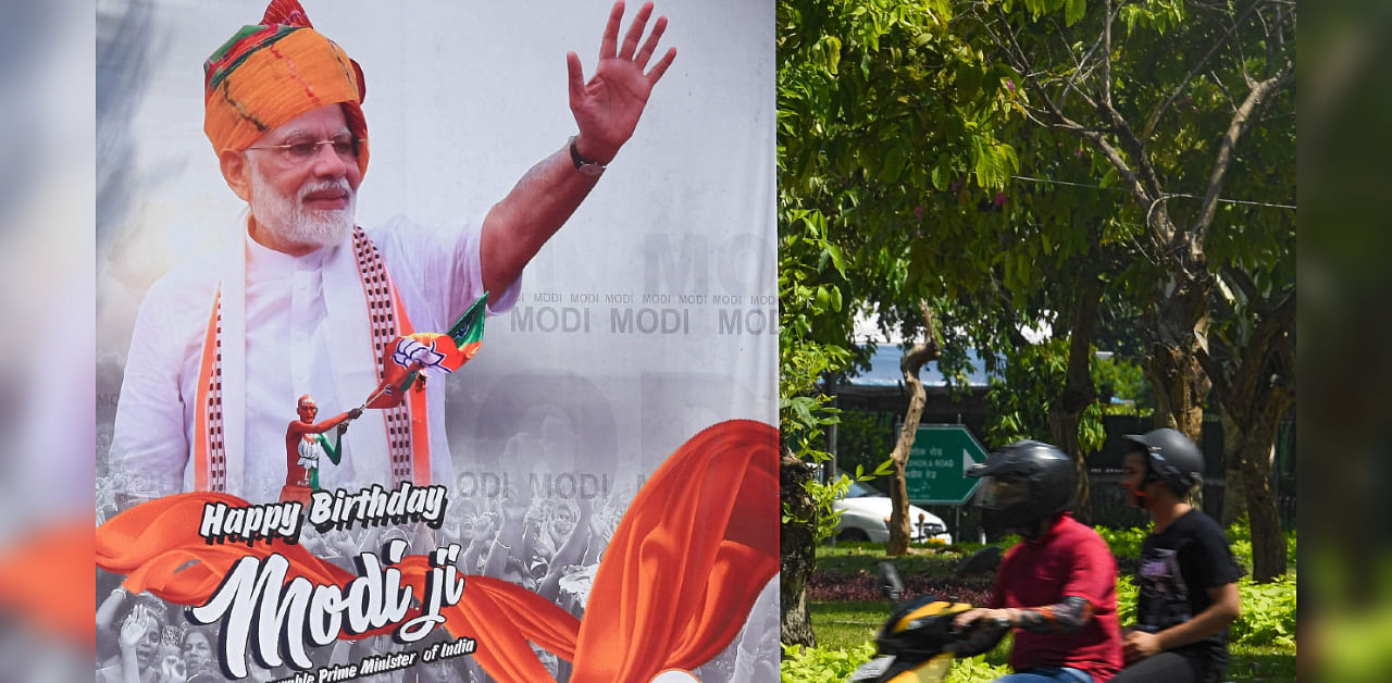 Motorists ride past a poster with a giant portrait of Indian Prime Minister Narendra Modi on his 70th birthday, in New Delhi on September 17, 2020. Credit: AFP