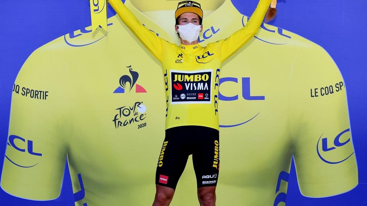 Team Jumbo rider Slovenia's Primoz Roglic celebrates his overall leader yellow jersey on the podium at the end of the 18th stage of the 107th edition of the Tour de France cycling race, 168 km between Meribel and La Roche sur Foron. Credit: AFP