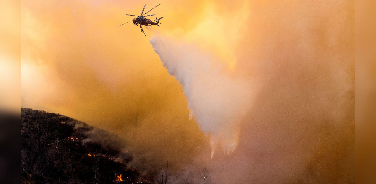 A helicopter makes a water drop over a wildfire in the Angeles National Forest during the Bobcat Fire in Los Angeles, California, US, September 17, 2020. Credit: REUTERS Photo
