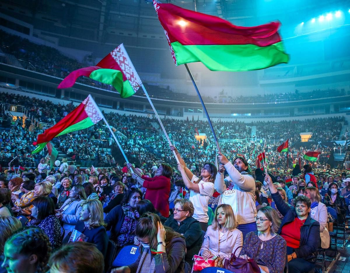 Supporters of the Belarusian President wave Belarus national flags as they attend the forum of Union of Women in Minsk on September 17, 2020. Credit: AFP