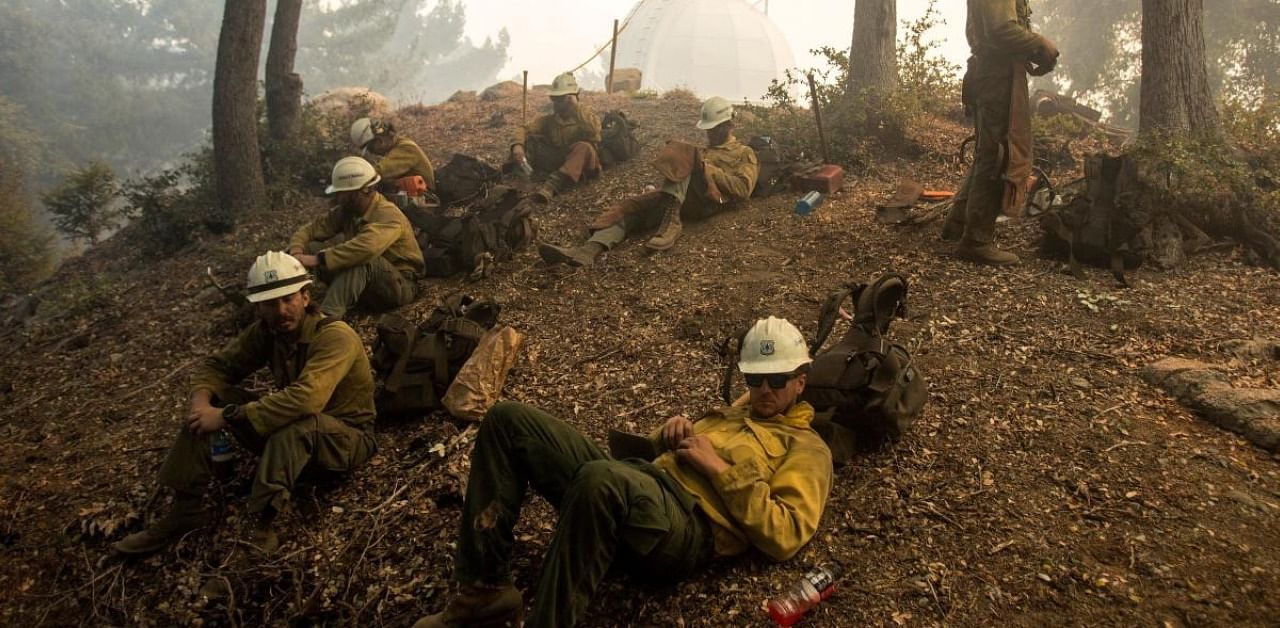 Firefighters rest while defending the Mount Wilson observatory during the Bobcat Fire in Los Angeles, California. Credit: Reuters