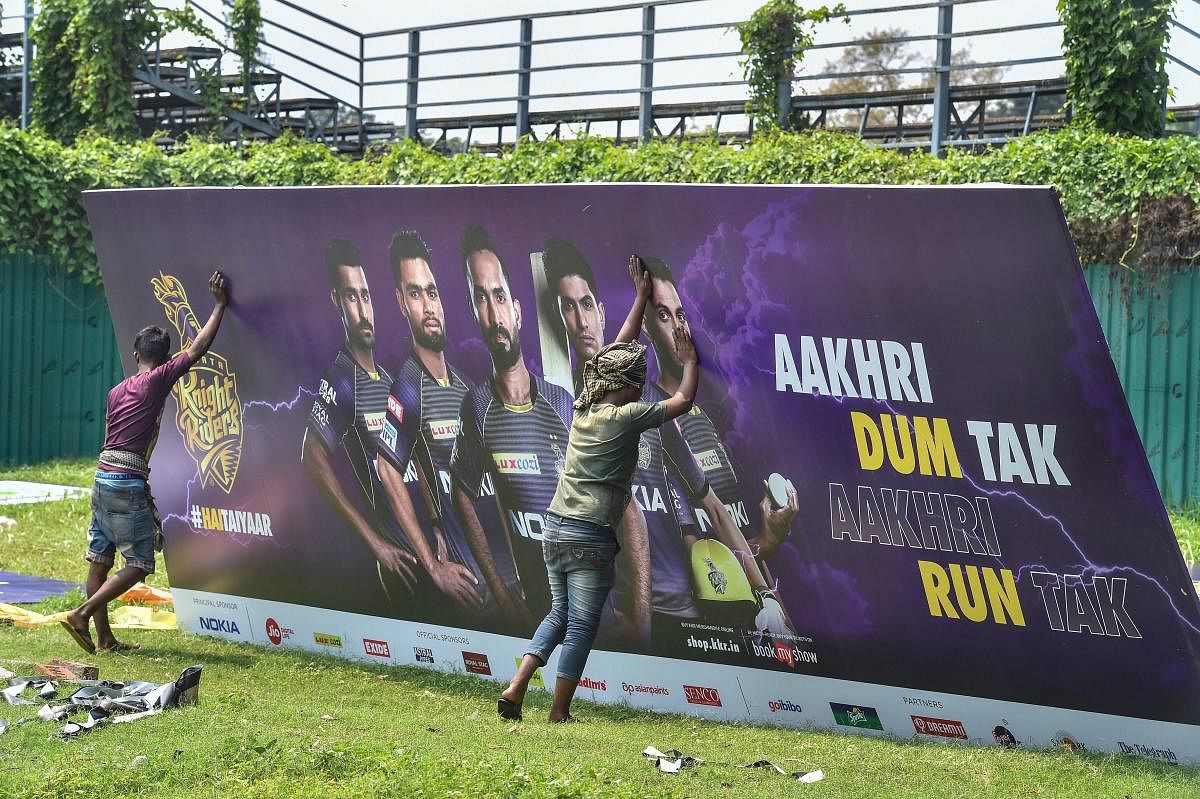 Workers fix a hoarding ahead of an Indian Premier League match in Kolkata on Tuesday. PTI file photo