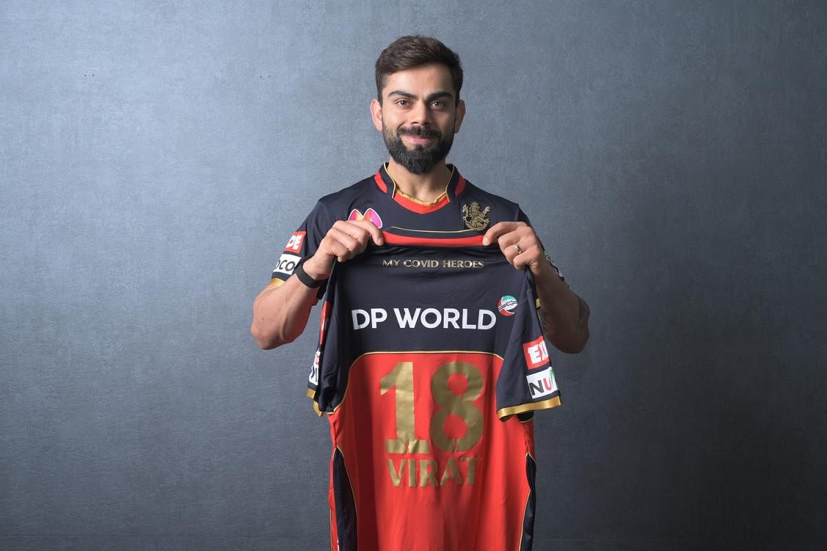 RCB skipper Virat Kohli shows the team's jersey with 'My Covid Heroes' emblazoned at the back during the launch on Thursday. RCB MEDIA  