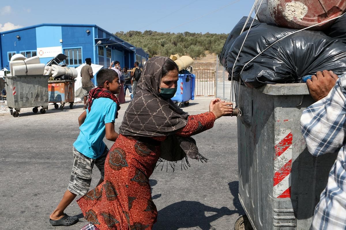 CRefugees and migrants who were sheltered near the destroyed Moria camp, carry their belongings as they prepare to move to a new temporary camp, on the island of Lesbos, Greece. Credit: Reuters
