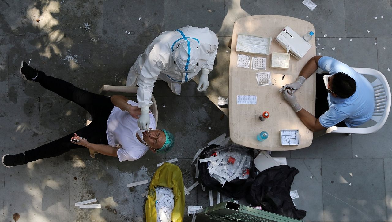 A health worker wearing personal protective equipment (PPE) collects a swab sample from a man. Credits: Reuters Photo