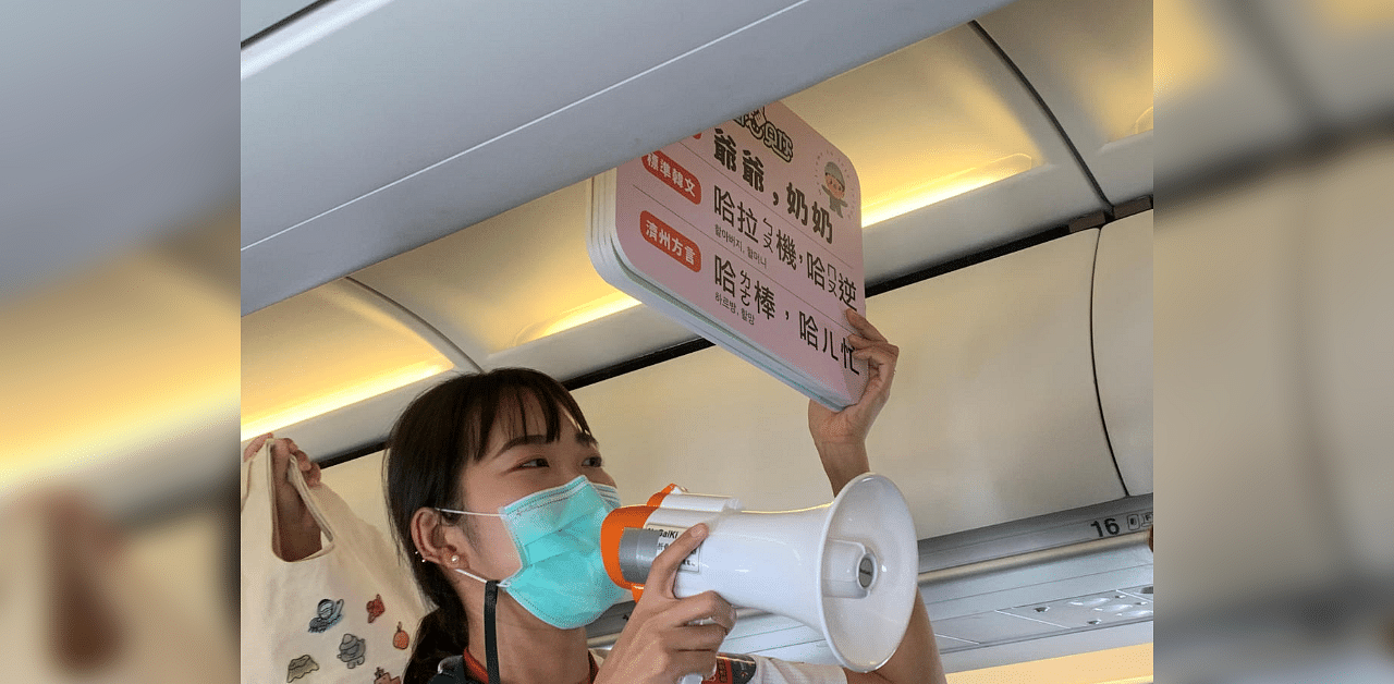 Guide holds signs on a Tigerair Taiwan flight that circles over South Korea's Jeju Island before returning to Taoyuan. Credit: Reuters