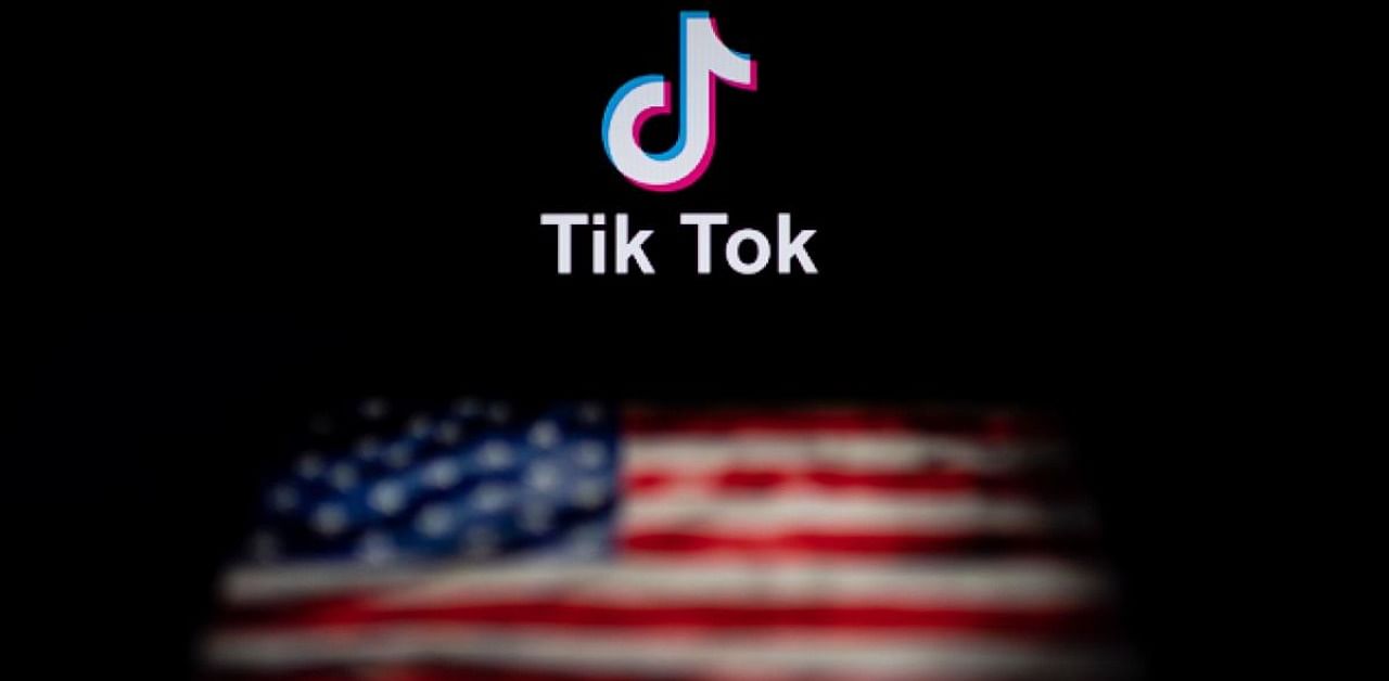 The logo of the social network application TikTok and a US flag on the screens of two laptops in Beijing. Credit: AFP