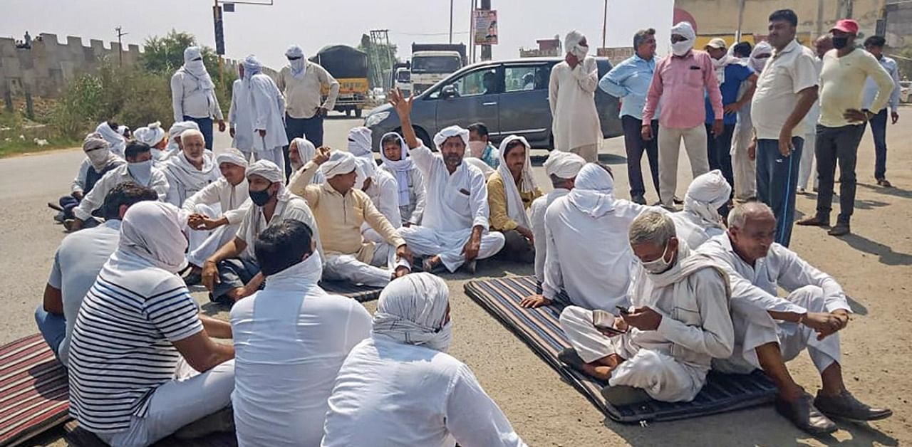 Members of various farmer associations block a road as they stage a protest against Central Government over agriculture related ordinances, in Sonipat district. Credit: PTI