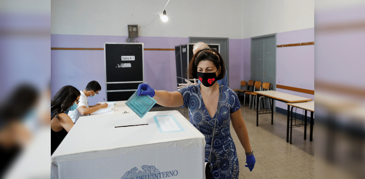 A woman casts her vote on a referendum to sanction a proposed cut in the number of Italian parliamentarians, in Rome, Italy September 20, 2020. Credit: Reuters Photo