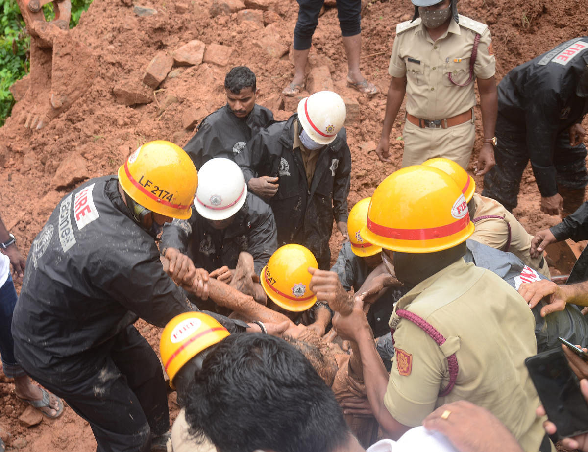 Fire service personnel and police carry out a rescue operation at the site where a compound wall collapsed, at Kuloor, on Saturday.