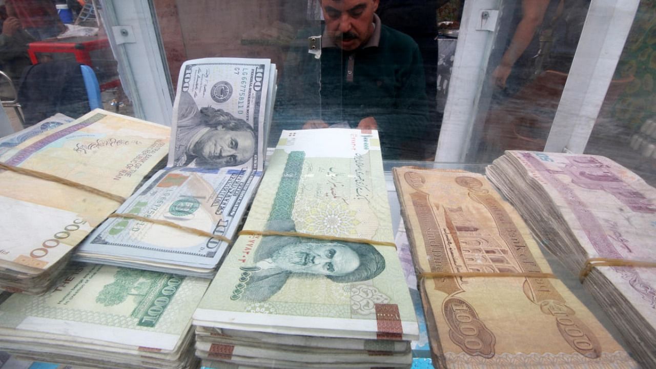 A man counts Iranian rials at a currency exchange shop, before the start of the US sanctions on Tehran. Credit: Reuters.