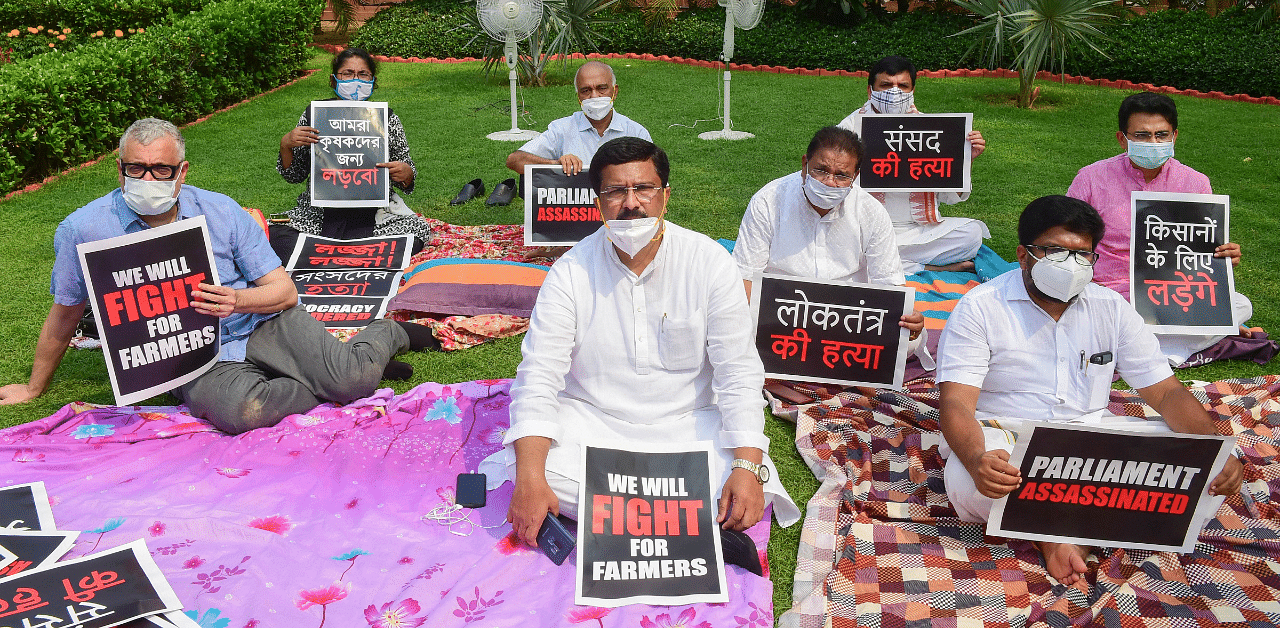 Eight suspended Rajya Sabha MPs display placards as they stage a protest over their suspension, during ongoing Monsoon Session of Parliament, in New Delhi. Credit: PTI Photo