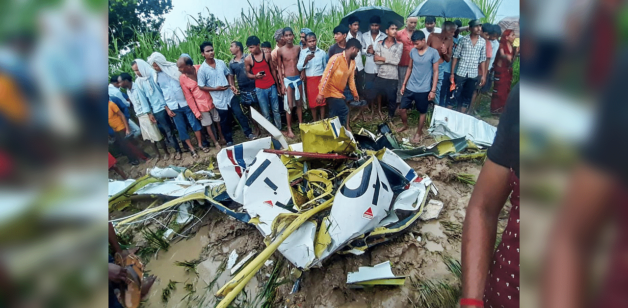 Locals gather near the mangled remains of a helicopter that crashed in UP's Azamgarh district, Monday, Sept. 21, 2020. Credit: PTI Photo