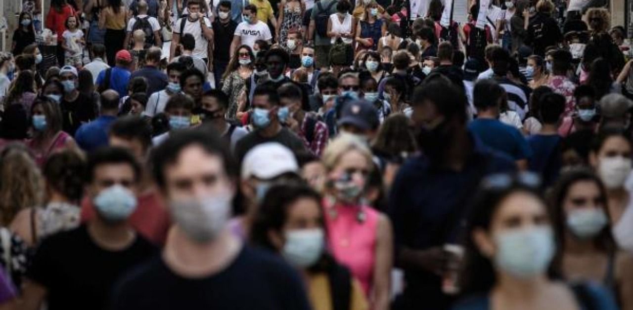 Pedestrians, some of them wearing protective face masks due to the Covid-19 coronavirus pandemic, walk in a street lined with shops in Bordeaux, southwestern France. Credit: AFP Photo