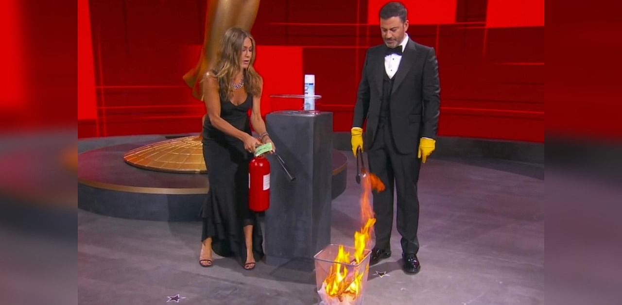 Jennifer Aniston and Jimmy Kimmel sanitize the winner's envelope during the 72nd Emmy Awards. Credit: AP Photo