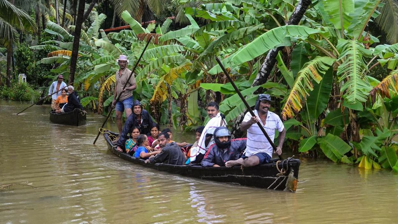 Locals along with NDRF personnel rescue villagers from Udupi and Dakshina Kannada and move them to safer places after heavy rain, in Mangaluru. Credit: PTI.