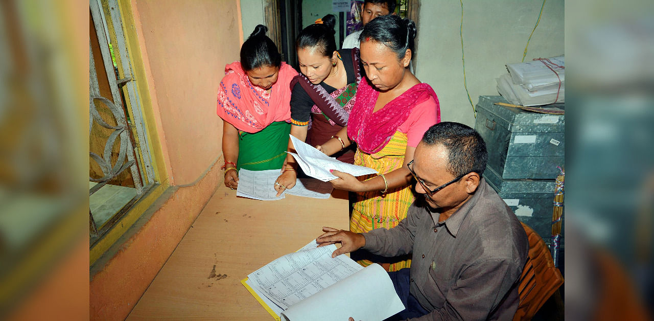 Bodo women check their names in the final list of National Register of Citizens (NRC), at an NRC Seva Kendra at Bagan Para in Baska district of Assam./ Representative image. Credit: PTI