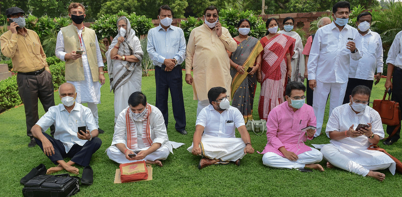 Suspended Rajya Sabha members (sitting at front) along with opposition parties members stage a protest over their suspension. Credits: PTI Photo