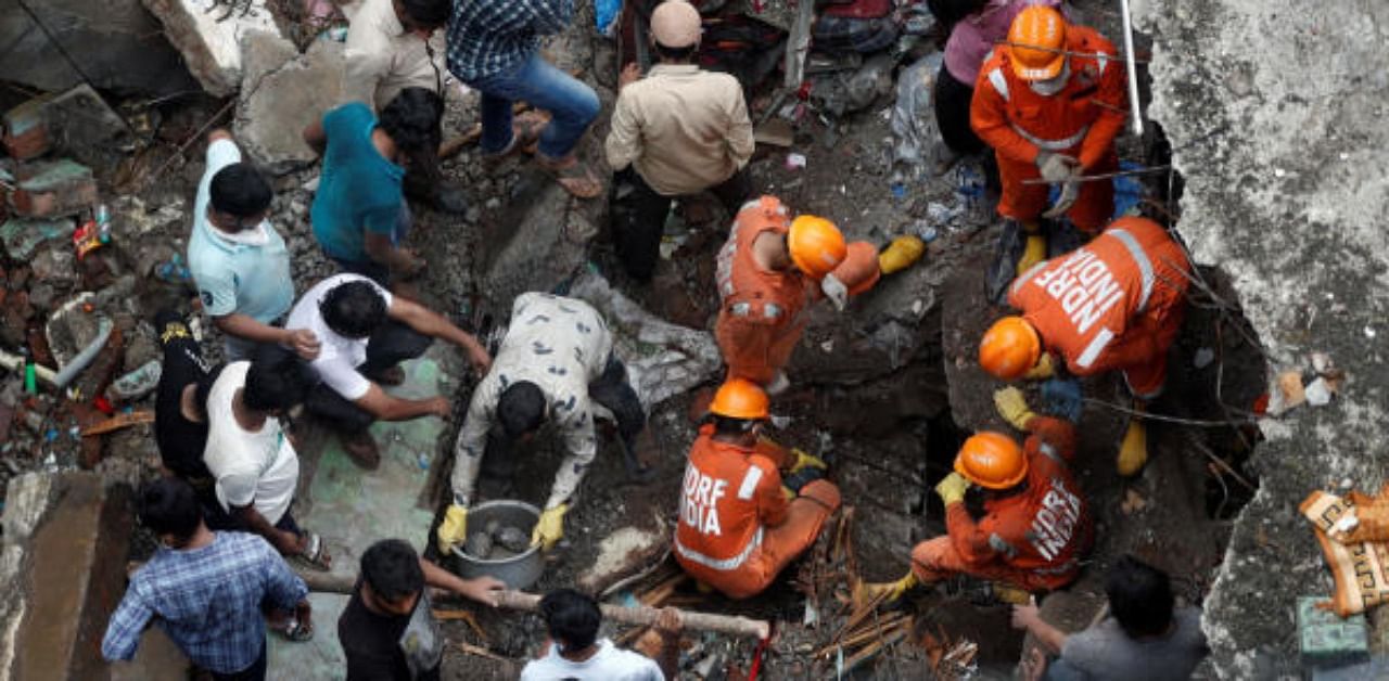 National Disaster Response Force (NDRF) officials search for survivors as people help clear the rubble after a three-storey building collapsed in Bhiwandi, on the outskirts of Mumbai, India. Credit: Reuters Photo