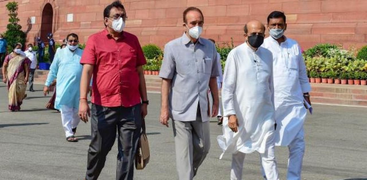 Congress MP Ghulam Nabi Azad, TMC MP Dinesh Trivedi and other opposition MPs stage a walkout from the Rajya Sabha, demanding suspension of 8 lawmakers be revoked, during the ongoing Monsoon Session of Parliament, at Parliament House in New Delhi. Credit: PTI Photo
