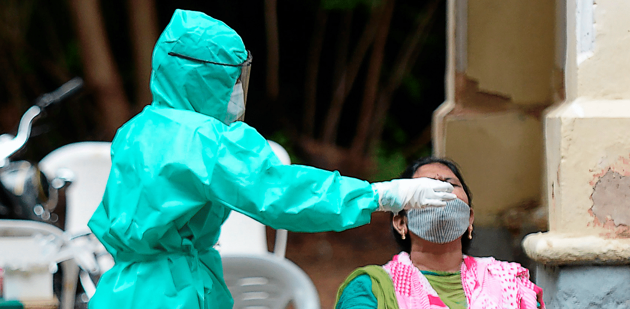 A health worker collects a swab sample from a woman to test for the Covid-19. Credit: AFP Photo