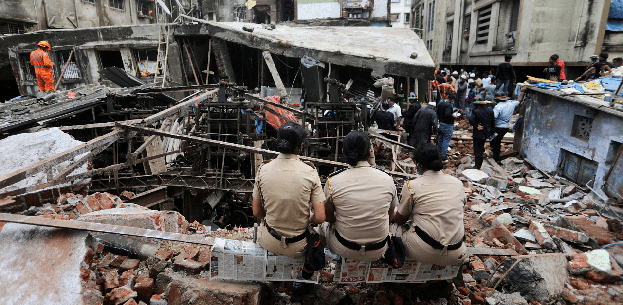 Police officers watch rescue operations after a three-storey building collapsed in Bhiwandi, on the outskirts of Mumbai, India. Credit: Reuters Photo