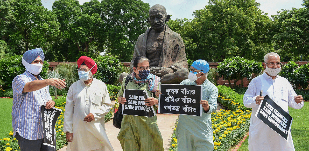 Congress MP Pratap Singh Bajwa, RJD MP Manoj Jha (C) and other opposition lawmakers march from Gandhi statue to Ambedkar statue in protest against the recent farm and labour bills, during the ongoing Monsoon Session, at Parliament House. Credit: PTI Photo