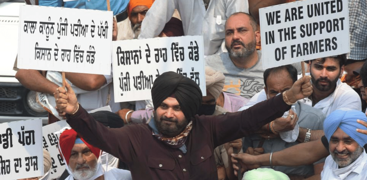The cricketer-turned-politician, who was accompanied by his supporters, sat on a tractor here and held placards that read, "We are united in fight for farmers", in English and Punjabi. Credit: AFP Photo
