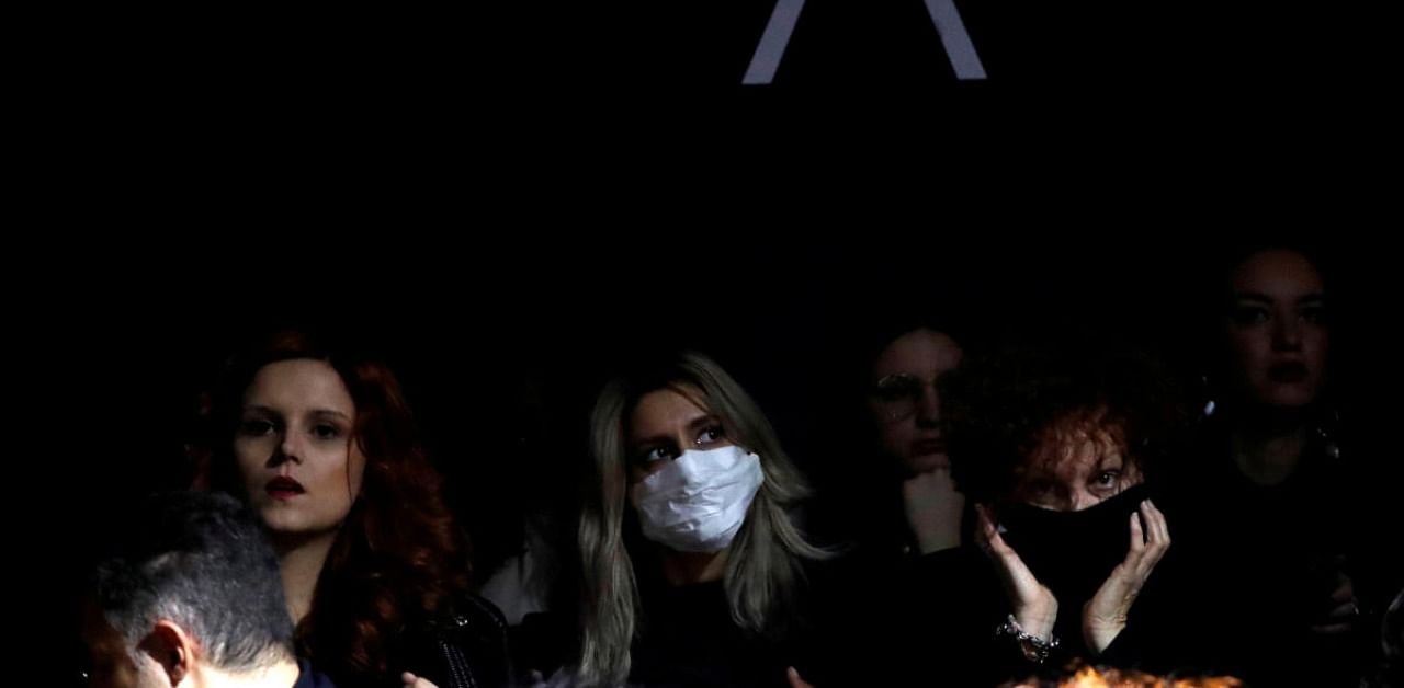 A person in the audience wears a mask as she attends Milan Fashion Week. Credit: Reuters Photo