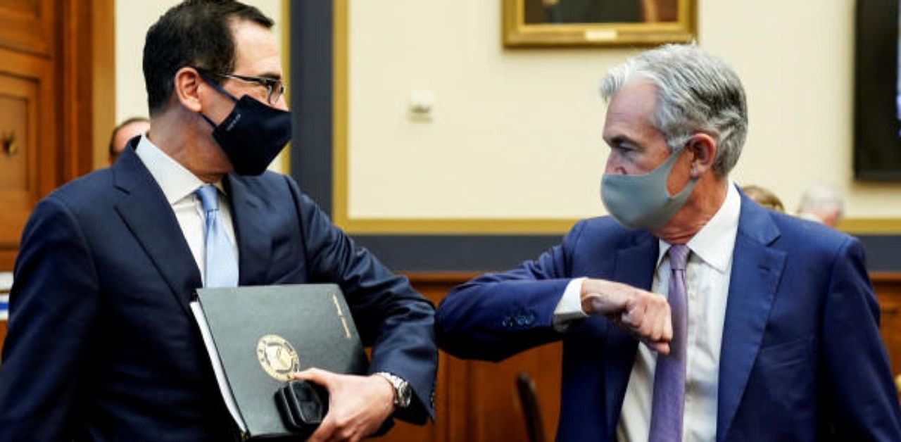 U.S. Treasury Secretary Steven Mnuchin and Federal Reserve Chair Jerome Powell share an elbow bump greeting prior to testifying before a House Financial Services Committee hearing on oversight of the Treasury Department's and Federal Reserve's coronavirus disease (COVID-19) pandemic response on Capitol Hill in Washington, U.S. Credit: Reuters Photo