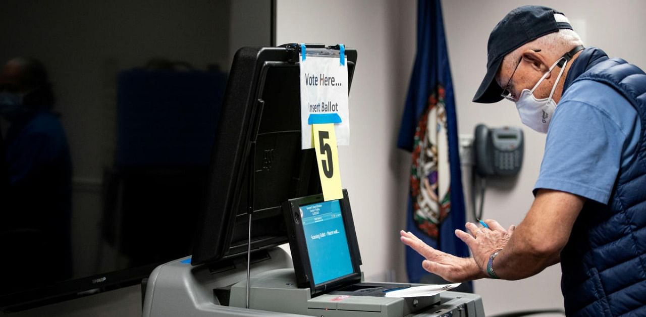 A man casts his ballot into a machine at an early voting site at the Fairfax County Government Center in Fairfax, Virginia, US. Credit: Reuters