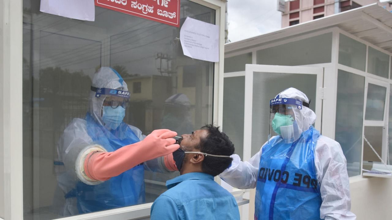 Medical staff collect a swab test for coronavirus at Dr B R Ambedkar Medical College and Hospital at Kadugondanahalli in Bengaluru. Credit: DH/SK Dinesh.