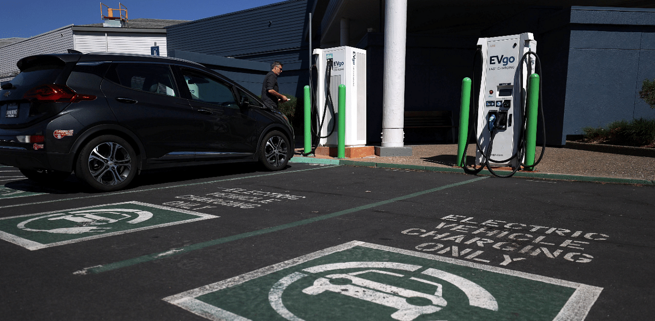 An electric car owner prepares to charge his car at an electric car charging station. Credit: AFP Photo
