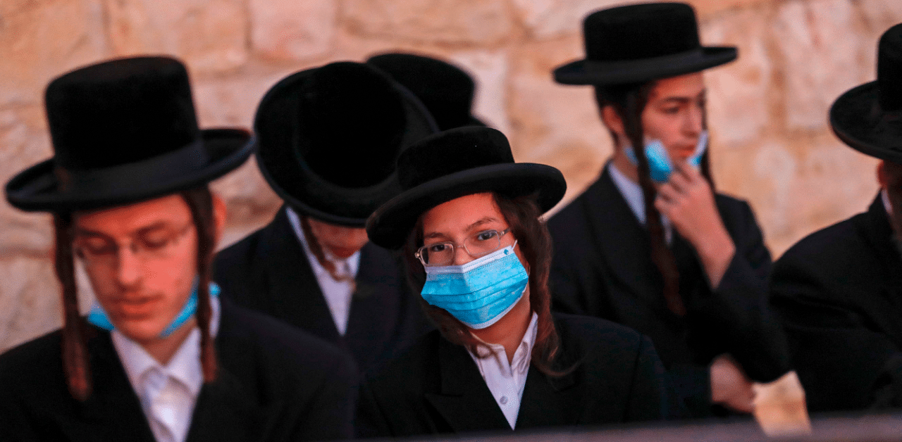 Ultra Orthodox Jews, wearing protective masks due to the Covid-19, pray in a cemetery at the Mount of Olives in east Jerusalem. Credit: AFP Photo